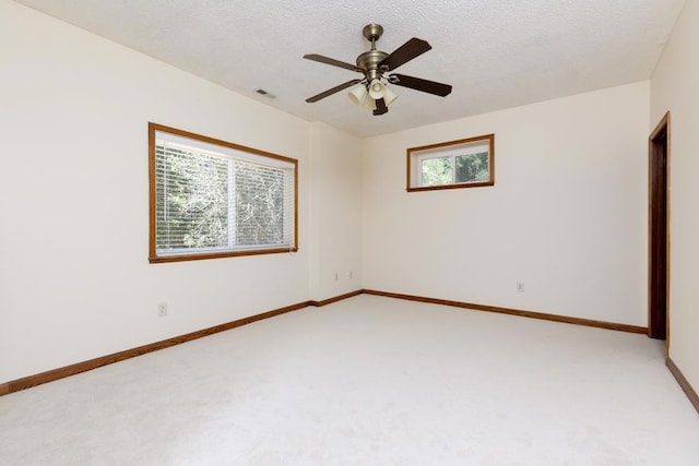 unfurnished room featuring ceiling fan, light carpet, and a textured ceiling