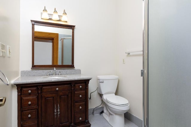 bathroom with toilet, tile patterned flooring, a shower with shower door, and vanity