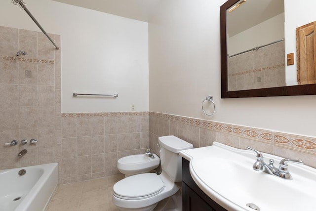 full bathroom featuring toilet, vanity, tile walls, tiled shower / bath combo, and a bidet