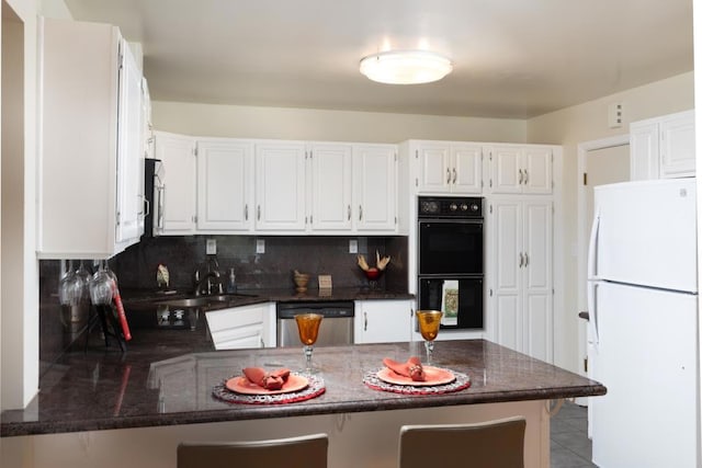 kitchen featuring double oven, white fridge, sink, kitchen peninsula, and stainless steel dishwasher