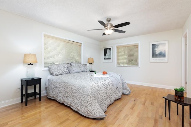 bedroom with ceiling fan, a textured ceiling, and hardwood / wood-style flooring