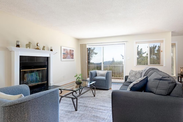 living room with a healthy amount of sunlight, a tile fireplace, and a textured ceiling