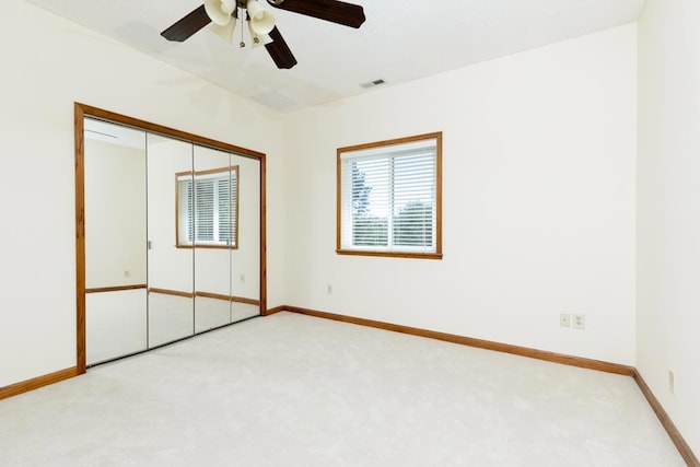 unfurnished bedroom with ceiling fan, a closet, and light colored carpet