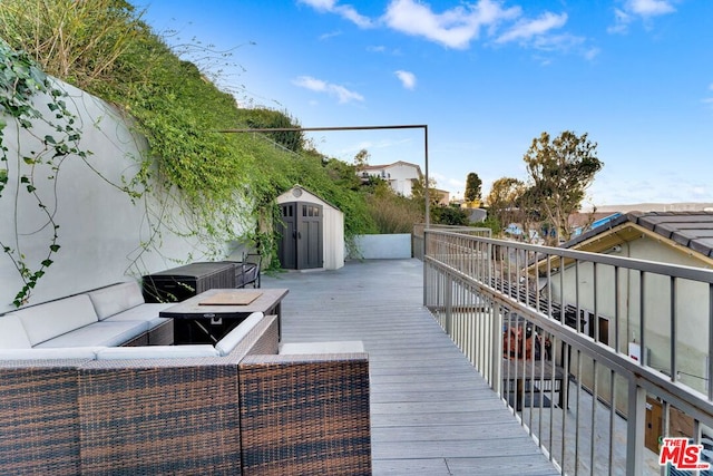 wooden terrace with outdoor lounge area and a shed