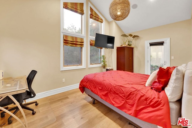 bedroom with lofted ceiling and light wood-type flooring