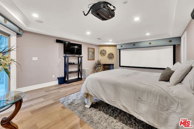 bedroom with ornamental molding and light hardwood / wood-style floors