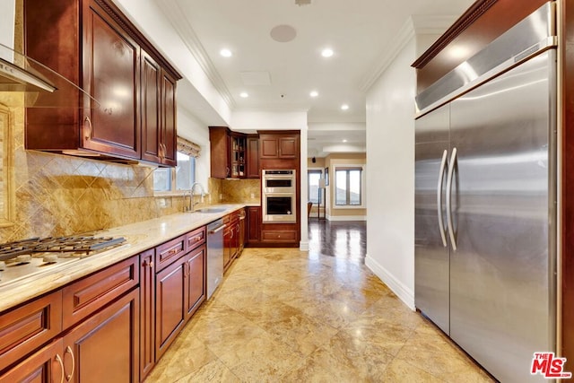 kitchen with stainless steel appliances, sink, backsplash, light stone counters, and crown molding