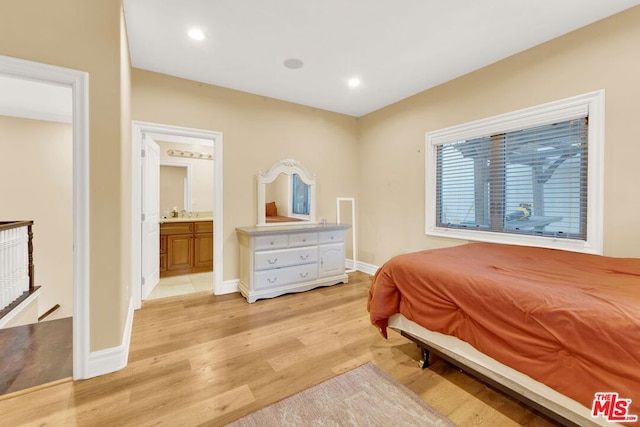 bedroom with light wood-type flooring and ensuite bath