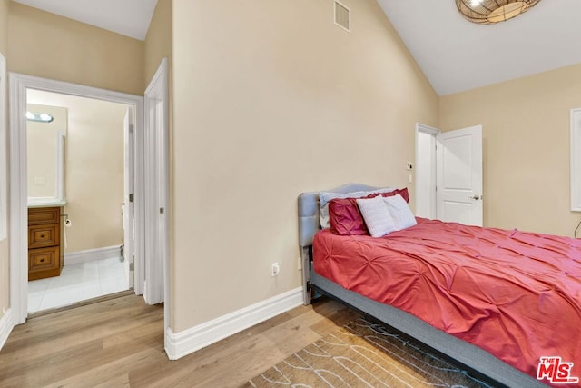 bedroom featuring lofted ceiling and light wood-type flooring