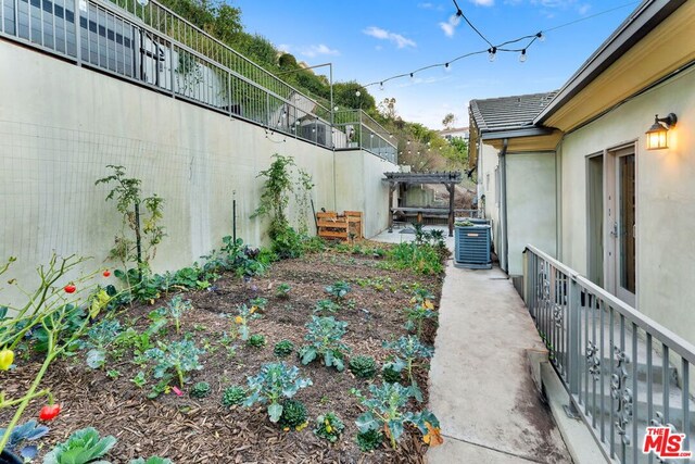 view of yard featuring a pergola and central air condition unit