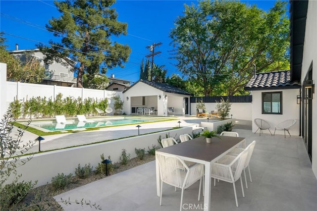 exterior space with a fenced in pool and an outbuilding