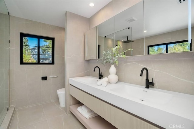 bathroom with toilet, vanity, tile walls, backsplash, and tile patterned floors