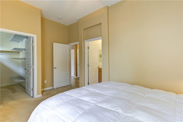 bedroom featuring a closet, a walk in closet, and light colored carpet