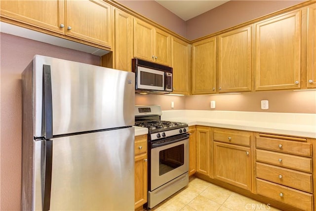 kitchen with light tile patterned flooring and stainless steel appliances