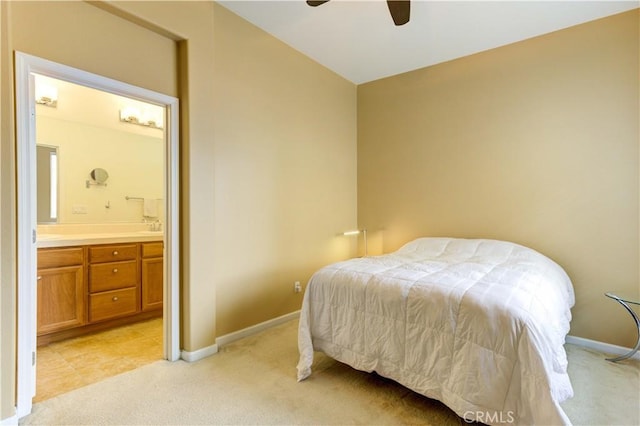 bedroom featuring ceiling fan, light carpet, and ensuite bath