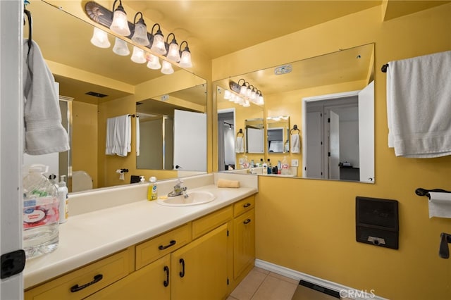 bathroom with walk in shower, vanity, and tile patterned flooring