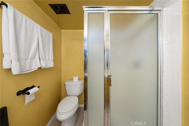 bathroom with a shower with shower door, toilet, and tile patterned flooring