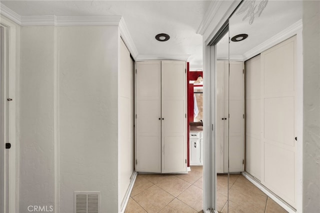 hallway featuring crown molding and light tile patterned flooring