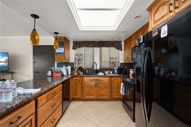 kitchen featuring decorative backsplash, black appliances, dark stone counters, pendant lighting, and sink