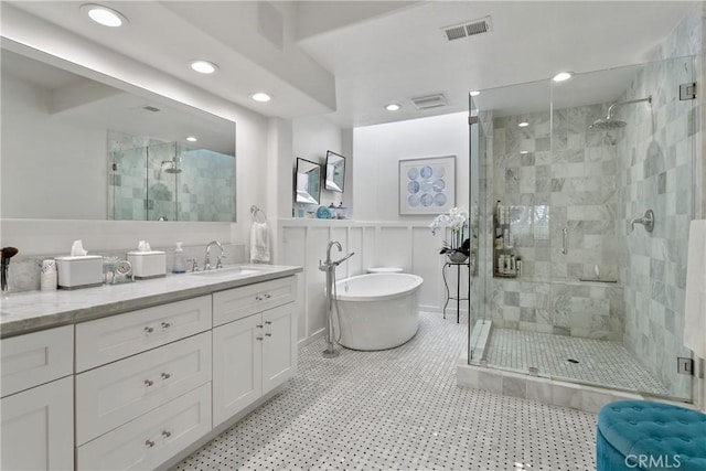 bathroom with visible vents, vanity, a freestanding tub, a shower stall, and recessed lighting