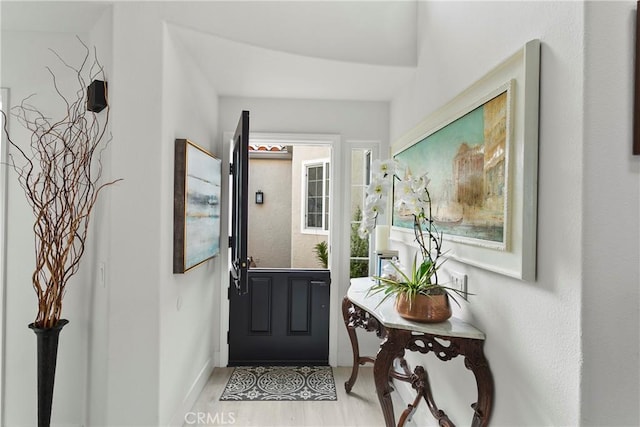 doorway featuring light wood-style floors and baseboards