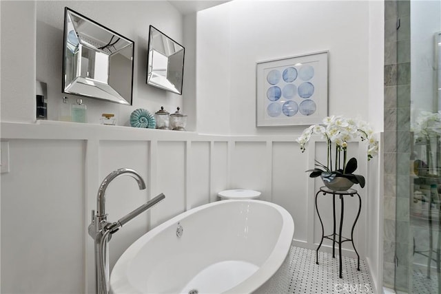 bathroom featuring a freestanding tub, a decorative wall, and a shower stall