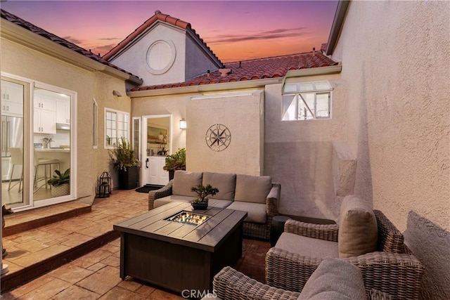 patio terrace at dusk featuring an outdoor living space with a fire pit