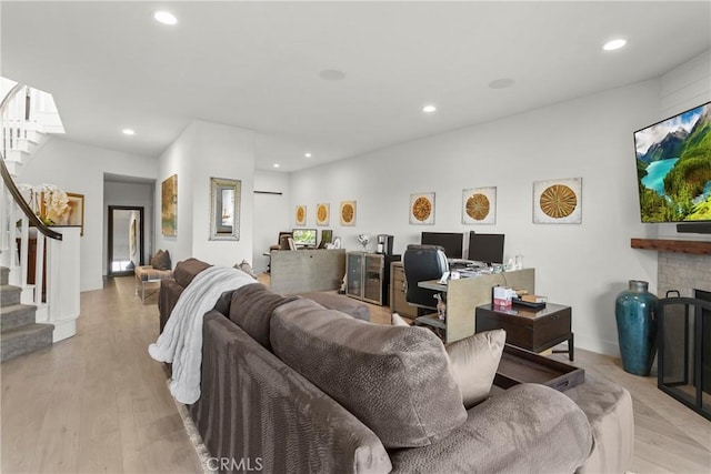 living room with a fireplace and light wood-type flooring