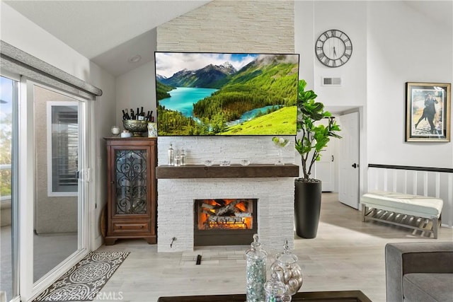 sitting room with lofted ceiling, a fireplace, and wood-type flooring