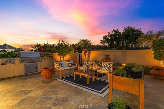 view of patio / terrace with an outdoor hangout area, area for grilling, exterior kitchen, and fence