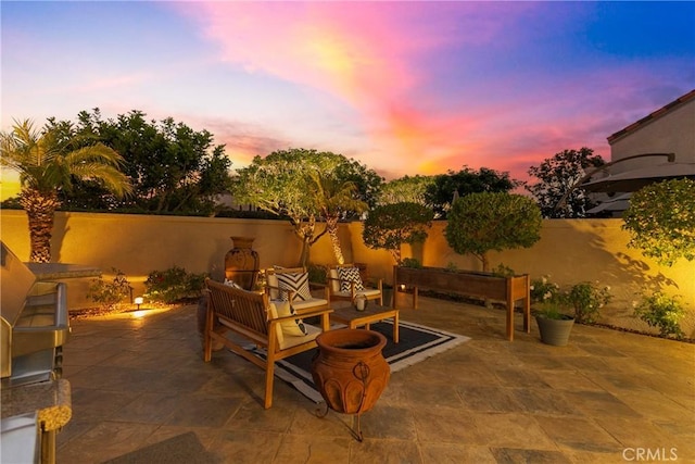 patio terrace at dusk with a fenced backyard