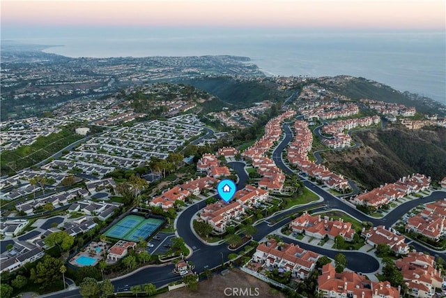 aerial view at dusk featuring a water view