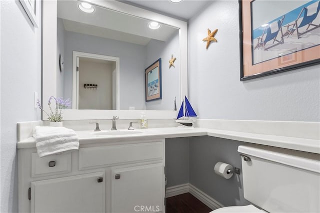 bathroom with vanity, toilet, and wood finished floors