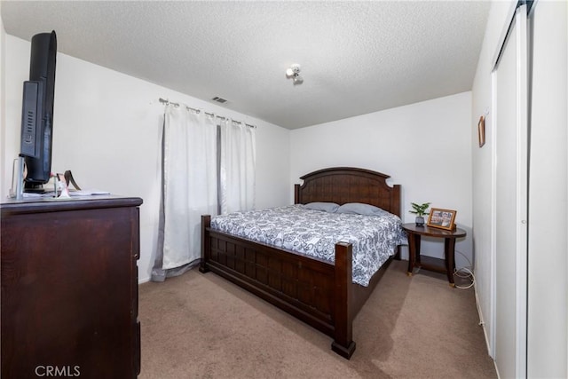 carpeted bedroom with a textured ceiling