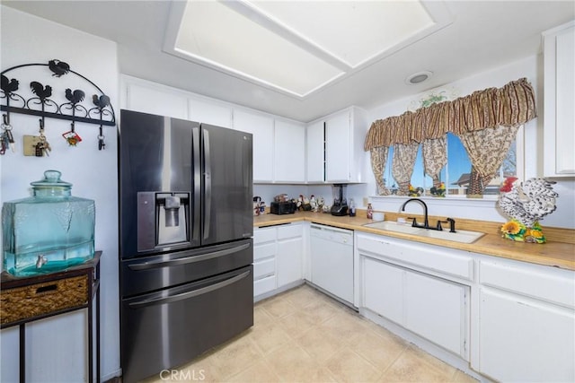 kitchen with sink, white cabinetry, stainless steel fridge, and dishwasher