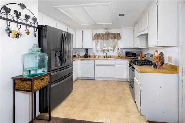 kitchen with stainless steel appliances, white cabinetry, and sink