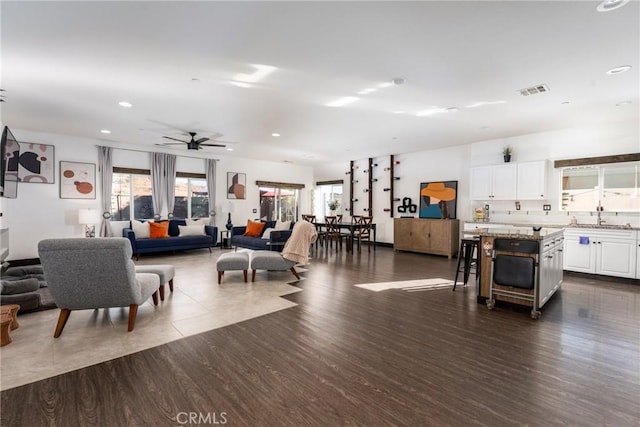 living room with ceiling fan, sink, dark hardwood / wood-style floors, and a healthy amount of sunlight