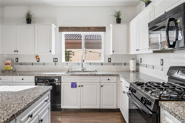 kitchen featuring white cabinetry, dark wood-type flooring, black appliances, light stone counters, and sink