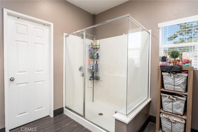 bathroom with wood-type flooring and an enclosed shower