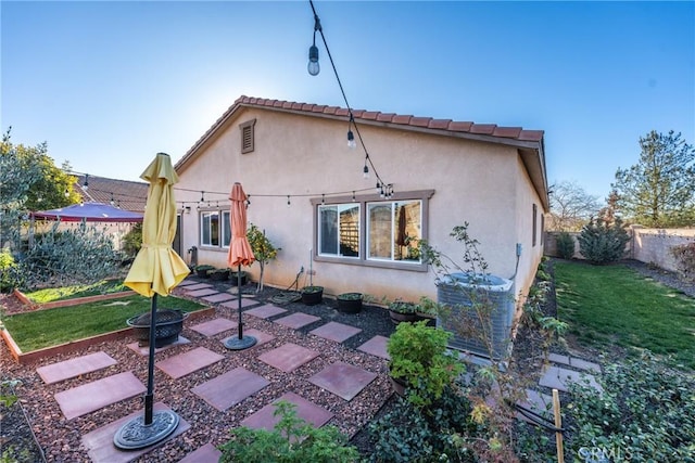 rear view of property with central AC unit, a patio area, and a yard