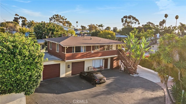 townhome / multi-family property featuring driveway, an attached garage, and stairs