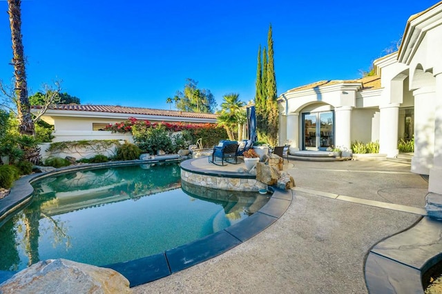 view of pool with french doors and a patio area