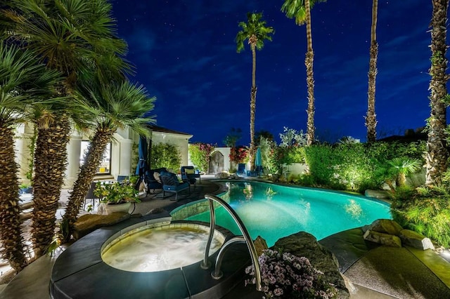 pool at night with an in ground hot tub