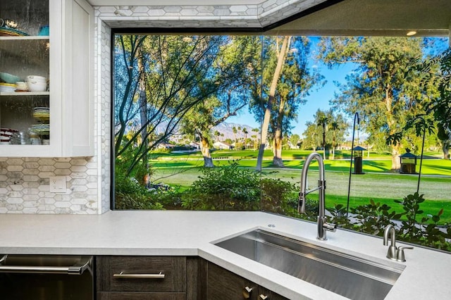 details with dishwasher, white cabinets, dark brown cabinetry, and sink