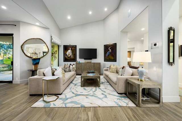 living room with hardwood / wood-style floors and high vaulted ceiling