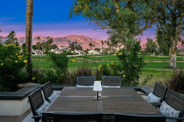 patio terrace at dusk featuring a mountain view