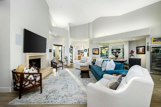 living room featuring indoor bar, beverage cooler, dark hardwood / wood-style floors, and high vaulted ceiling