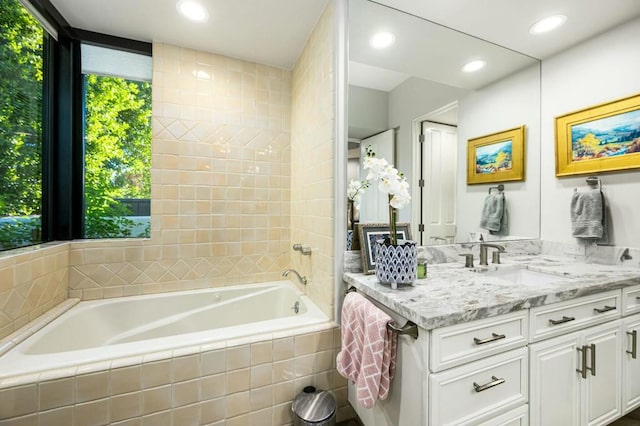 bathroom with a relaxing tiled tub and vanity