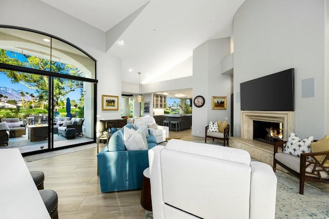 living room with high vaulted ceiling and a premium fireplace