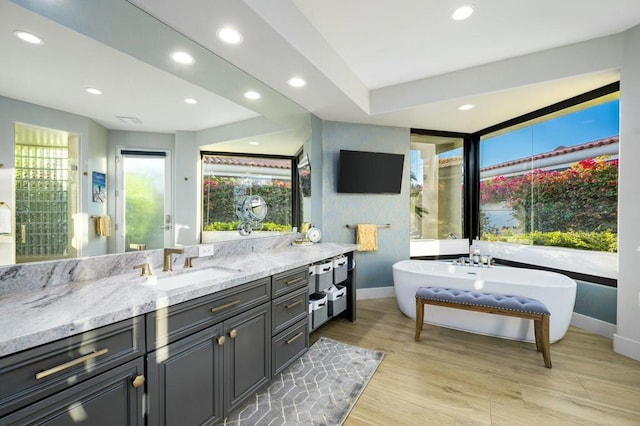 bathroom featuring vanity, a bathing tub, and hardwood / wood-style floors